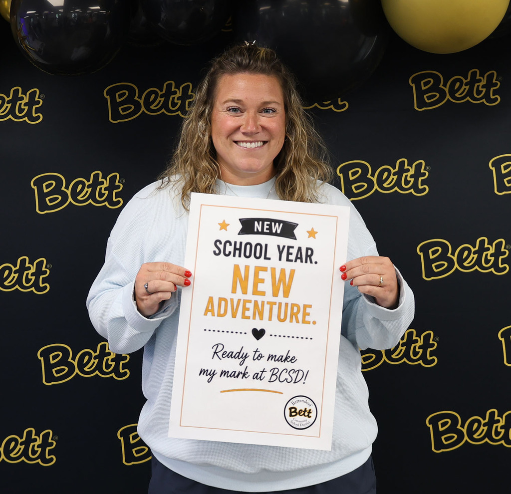 Alex Wendel with a sign - New school year. New adventure. heart. ready to make my mark at BCSD. Bettendorf Community School District logo with Bett graphic