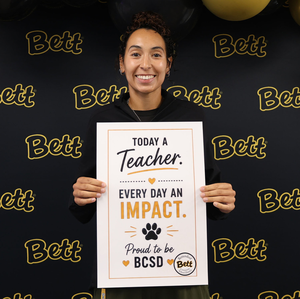 Kennedy Prince with a sign: Today a Teacher. Every day an impact. paw print. Proud to be BCSD. 