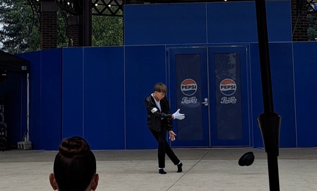 Liam perfoming on stage tossing his hat on stage