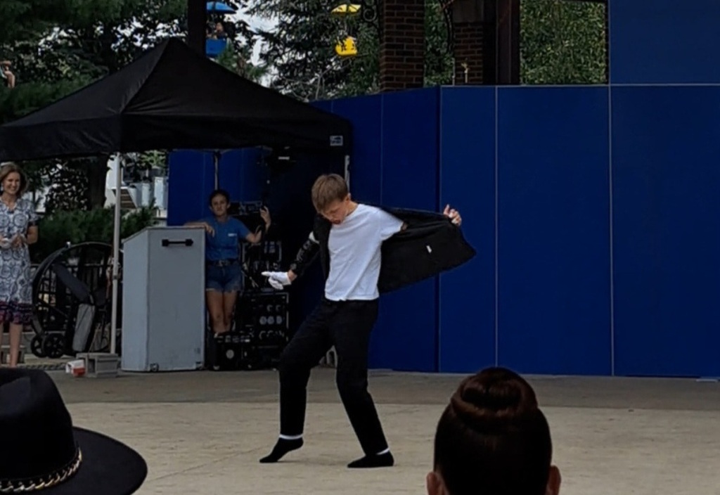 Liam perfoming on stage with his black jacket off his shoulder