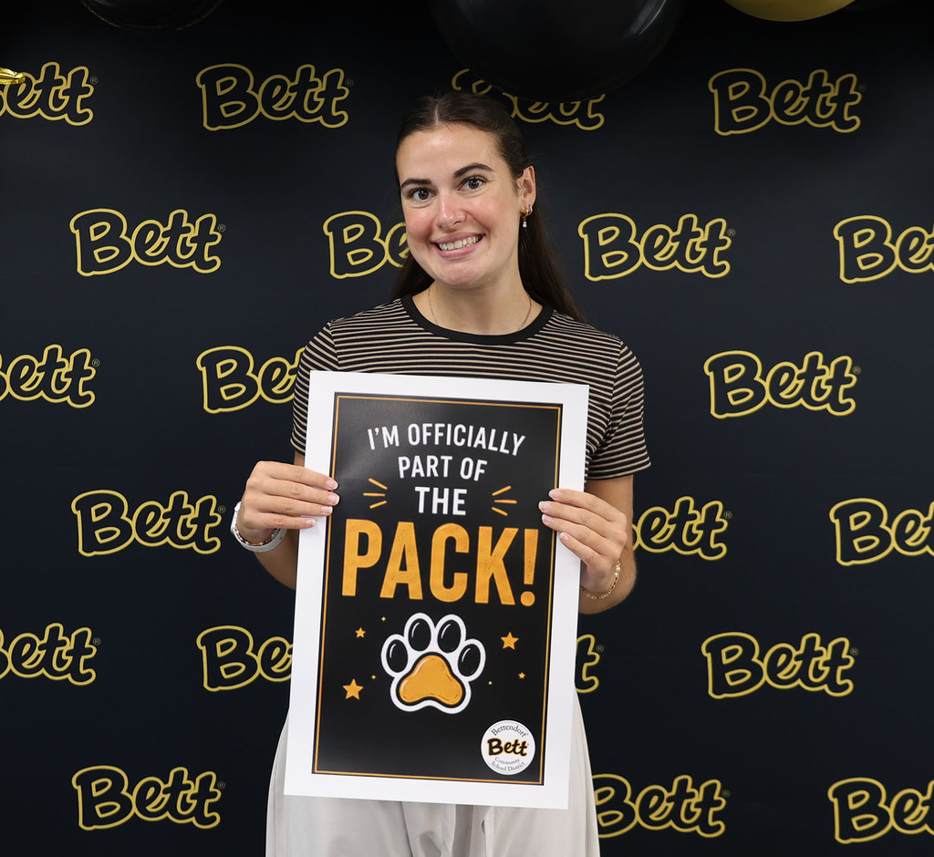 Olivia Wessell - BHS holding a sign: I'm officially part of the pack! Paw print! Bettendorf Community School District logo with Bett graphic.
