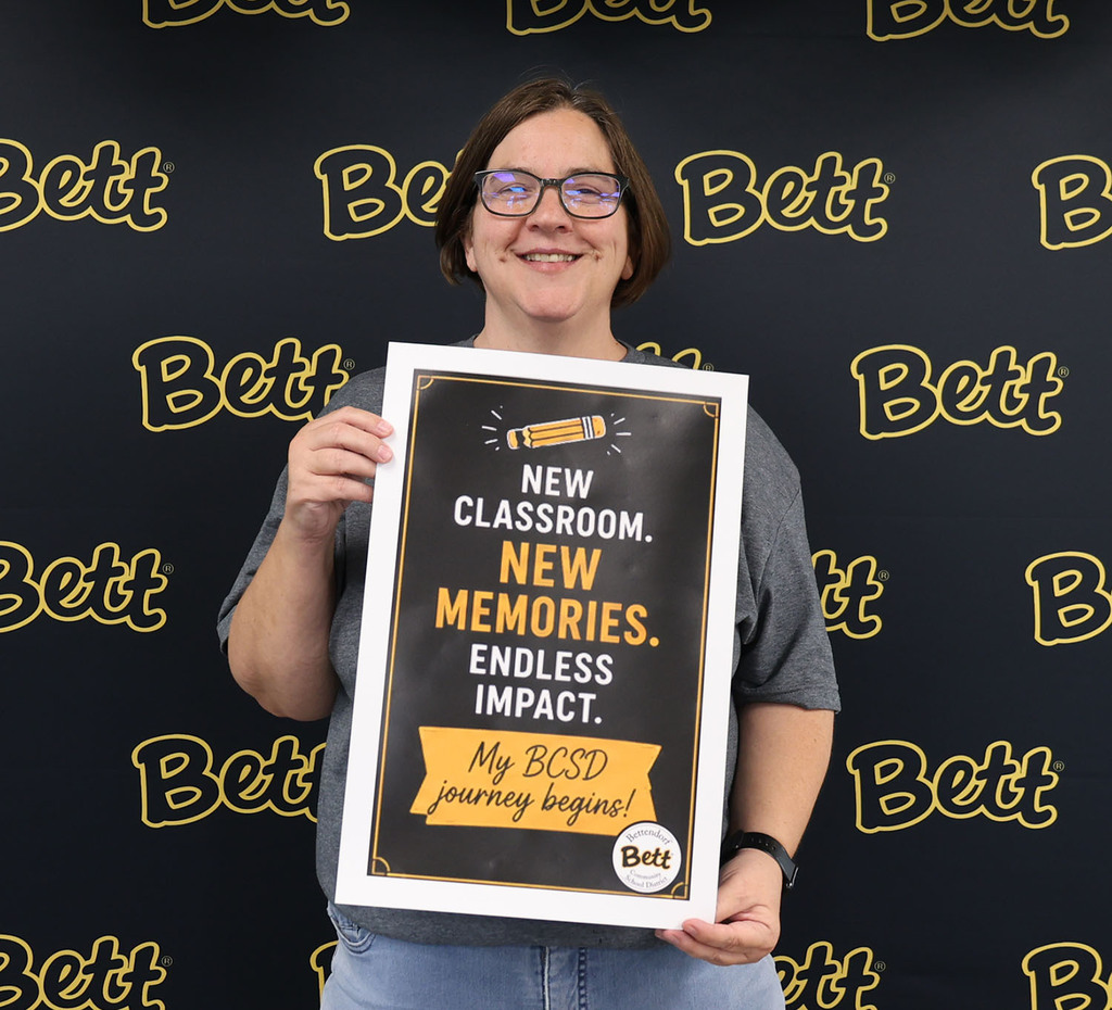 Mardell Brauer - MT -  holding a sign: pencil. New Classroom. New memories. endless impact. My BCSD journey begins!  Bettendorf Community School District logo with Bett graphic