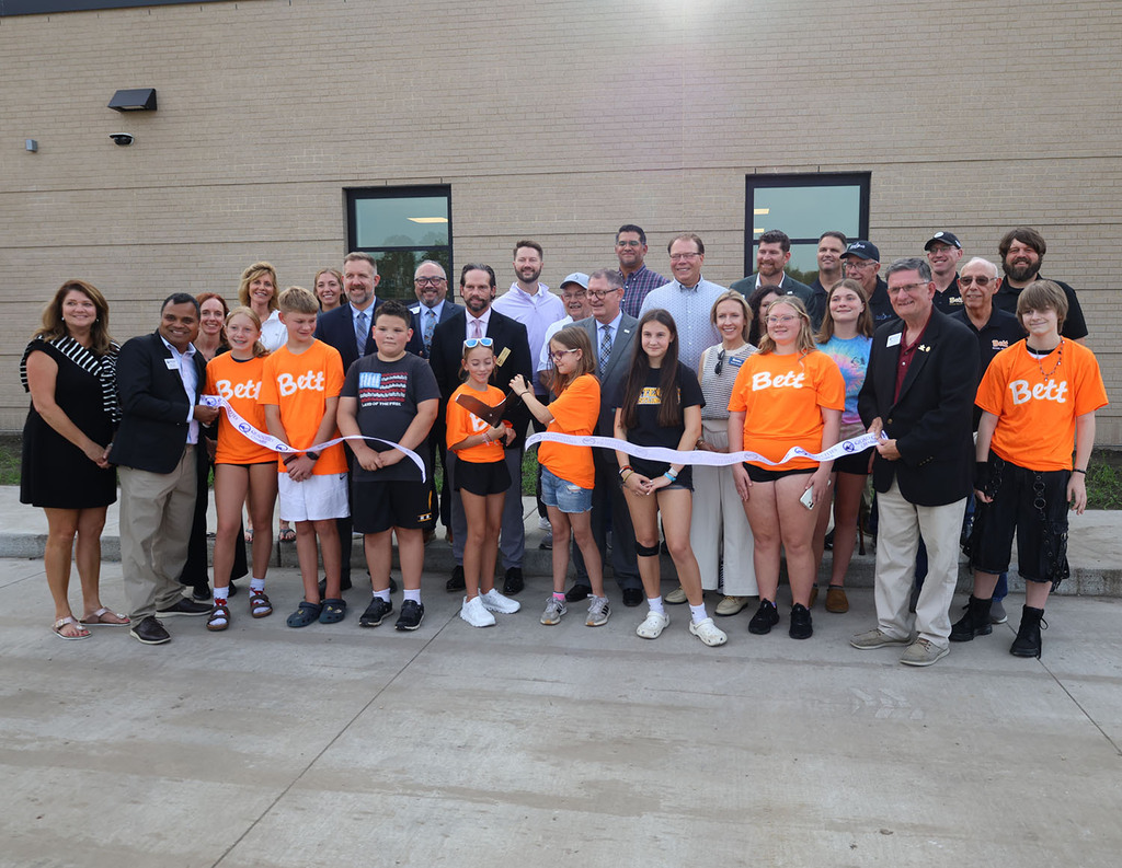 Two middle school students cut the ribbon