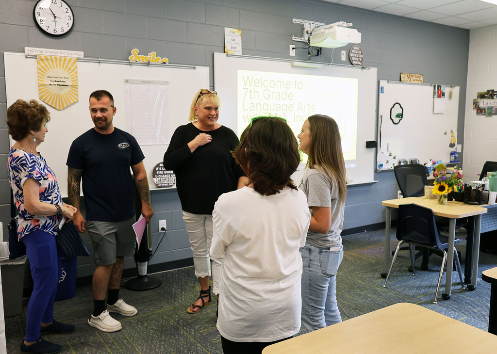 Teachers visiting with a family in a classroom