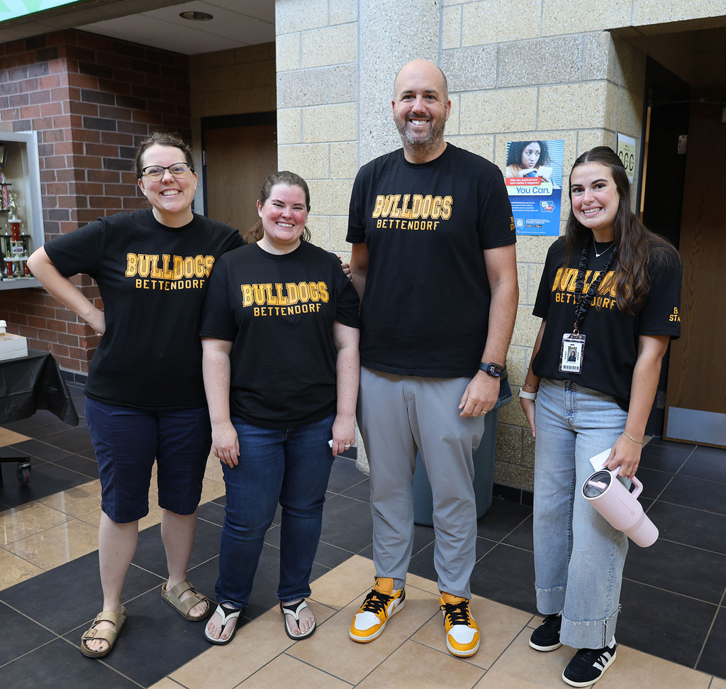 A group picture of four high school staff  with the Bettendorf Bulldog t-shirts