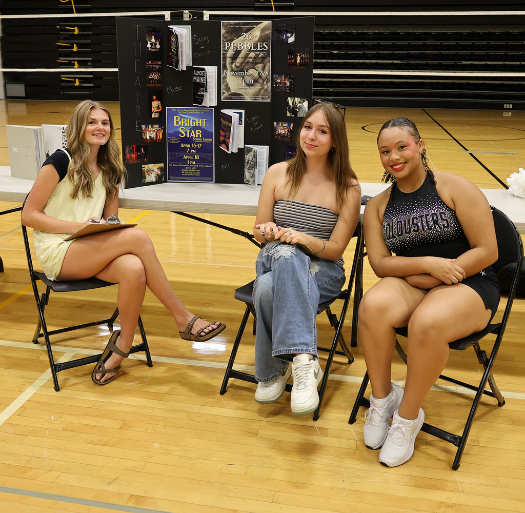 Three girls visiting with students about the theatre department