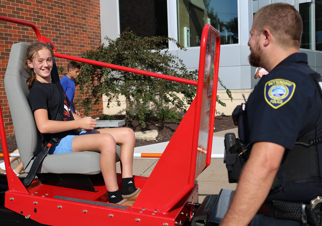 A girl smiling at the end of the seatbelt convincer experience