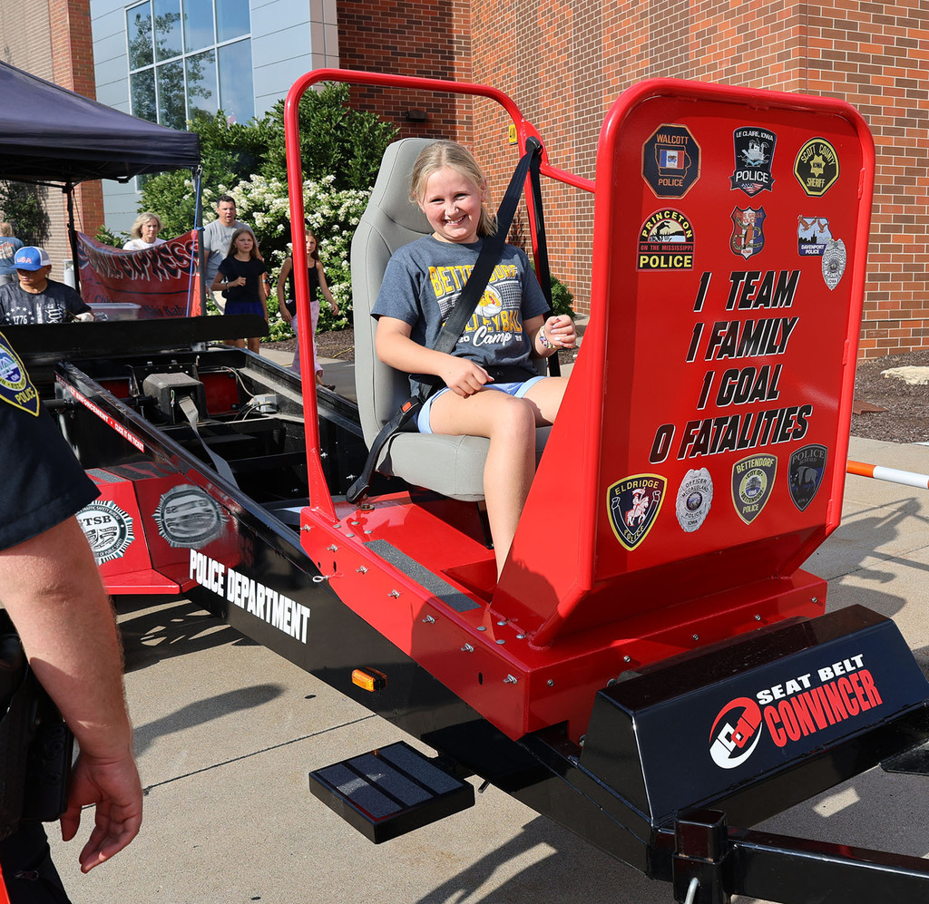 A young girl having a great tmie on the seat belt convincer