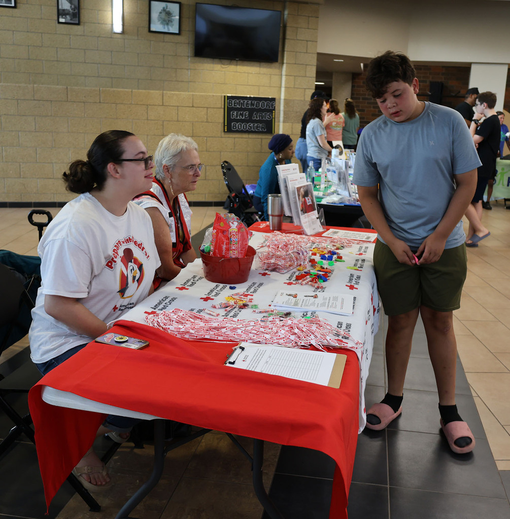 Red cross volunteers visiting with a student