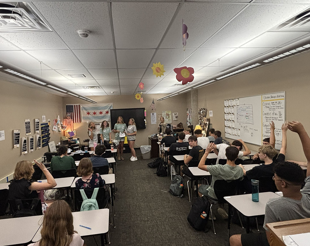 Four seniors lead a classroom of students in discussion