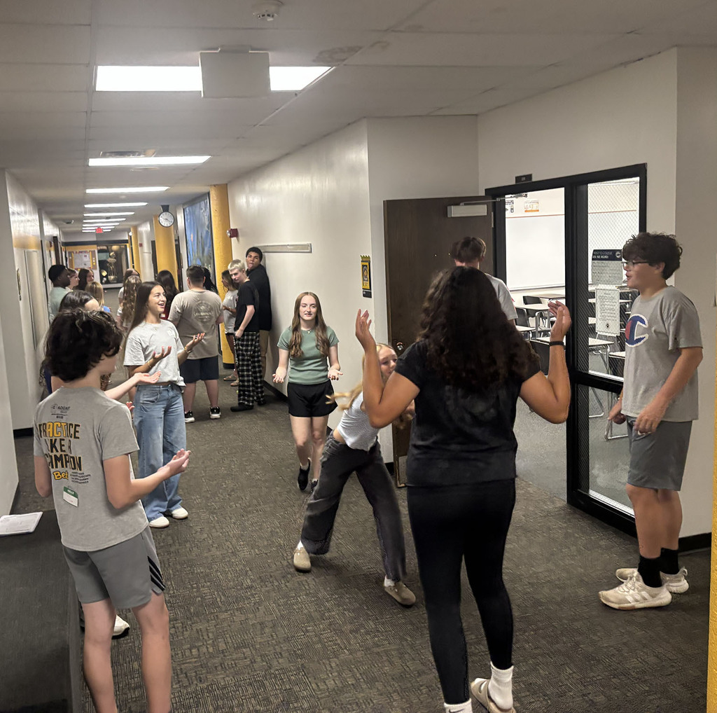 Students working together on small group activities to get to know each other in the hallway