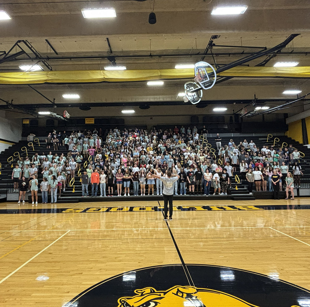 Students in the gym risers geeting warmed up with cheers and activities