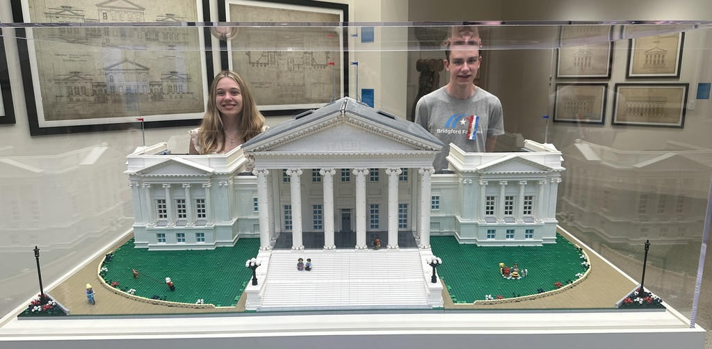 Students behind a miniture replica of the white house