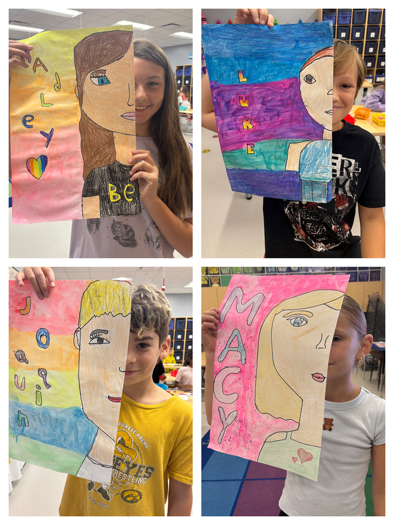 Students holding art work of half of their face with their namesin bubble letters next to the other half of their face