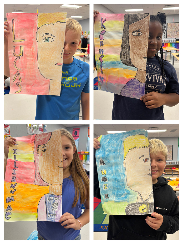 Students holding art work of half of their face with their namesin bubble letters next to the other half of their face