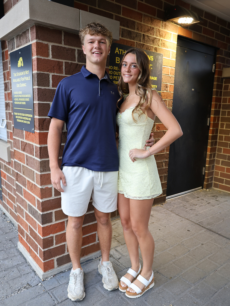 Tyler Nielsen and Haley Engels in front of the home ticket booth brick