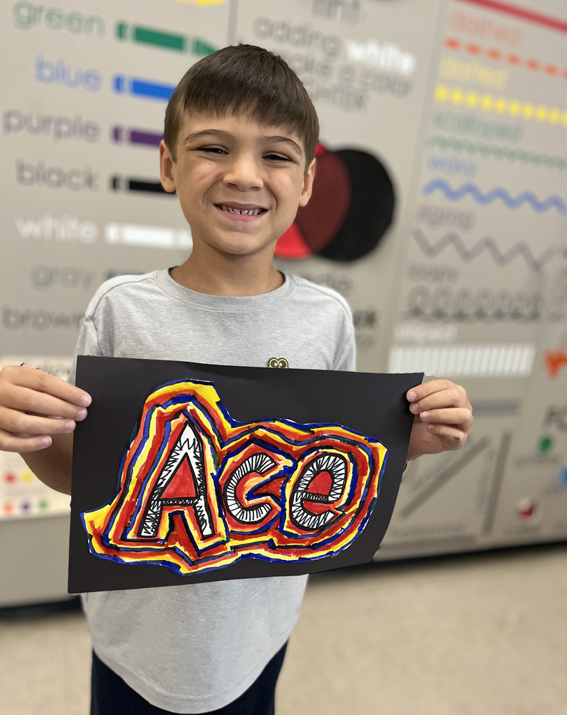 Ace smiling with his art design in black, orange, yellow and blue