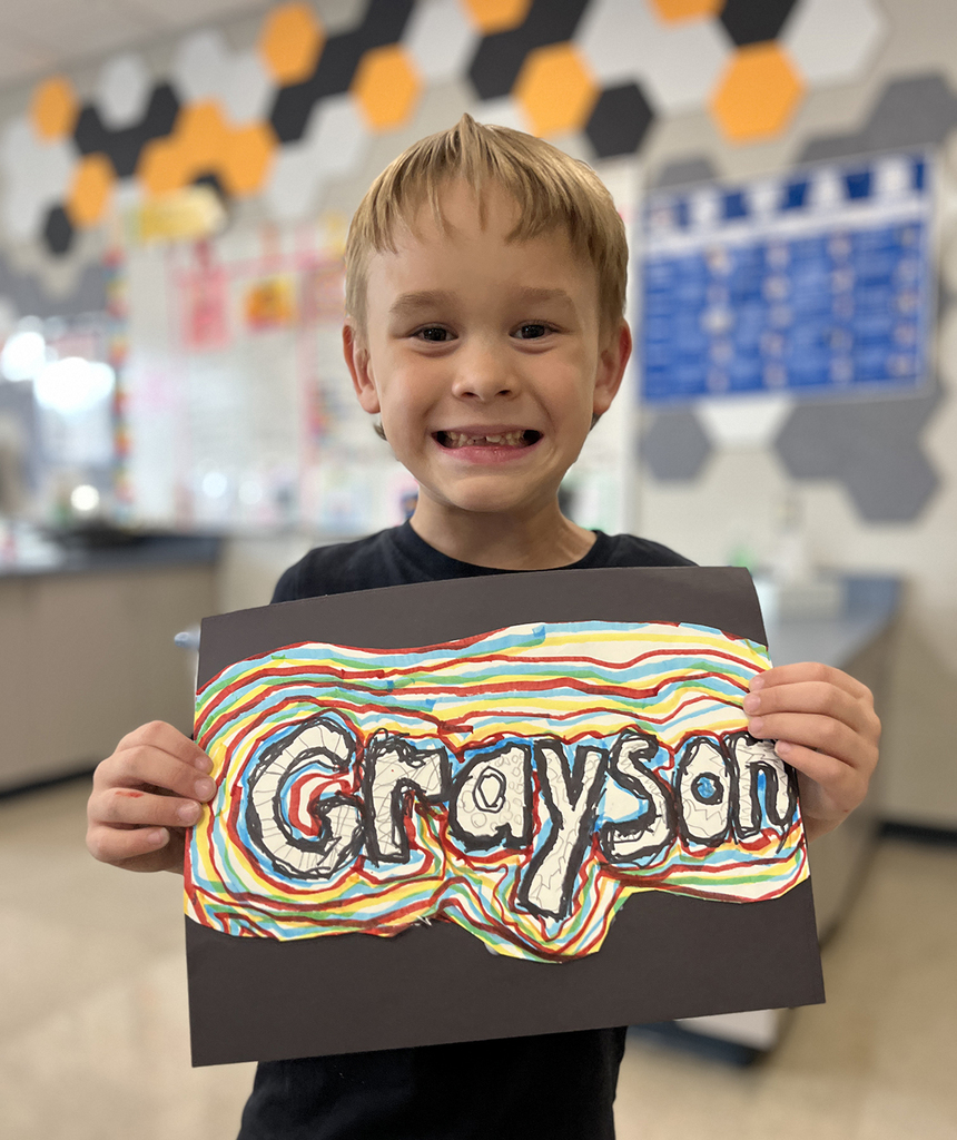 Grayson smiling with his art design