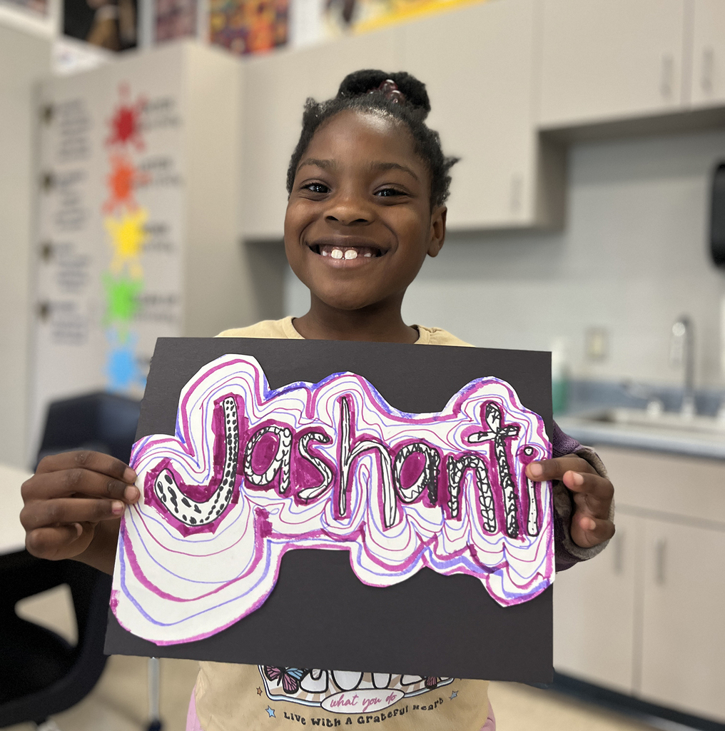 Jashanti smiling with her art design in black pink and purple