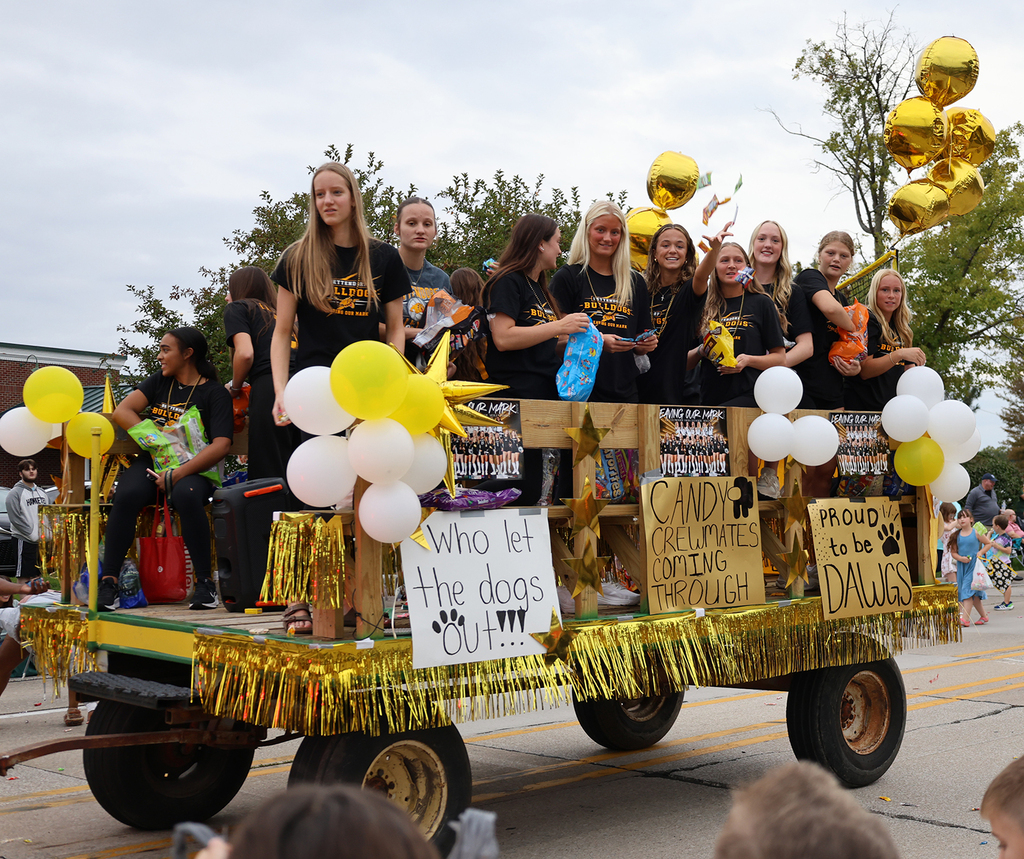 The volleyball team tossing out candy from the their float with volleyball posters and signs - Who let the dogs out! Candy crewmates coming through. Pround to be a dog.