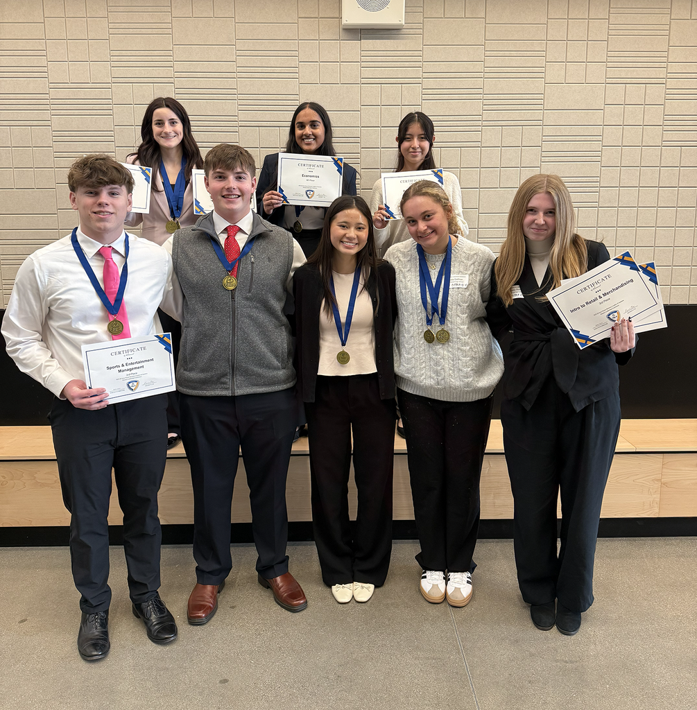 FBLA student wearing medals and holdng certificates