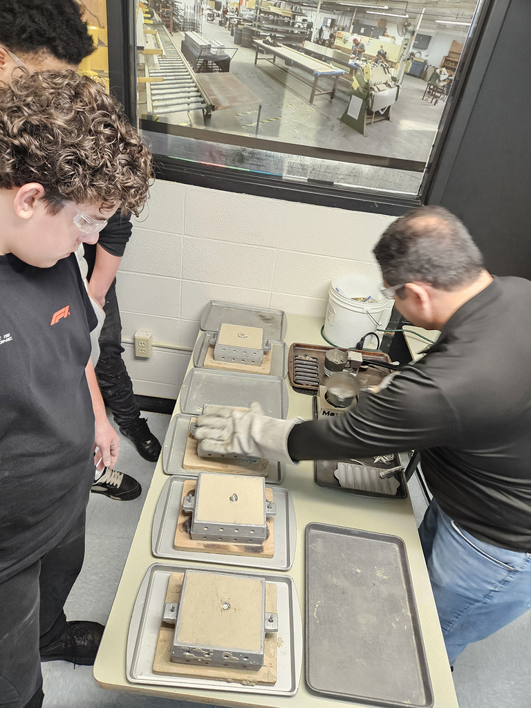Students workin with an adult on their casting boxes