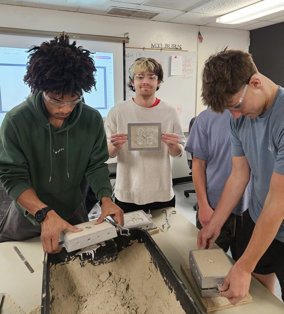 Students opening their casts into a container of sand