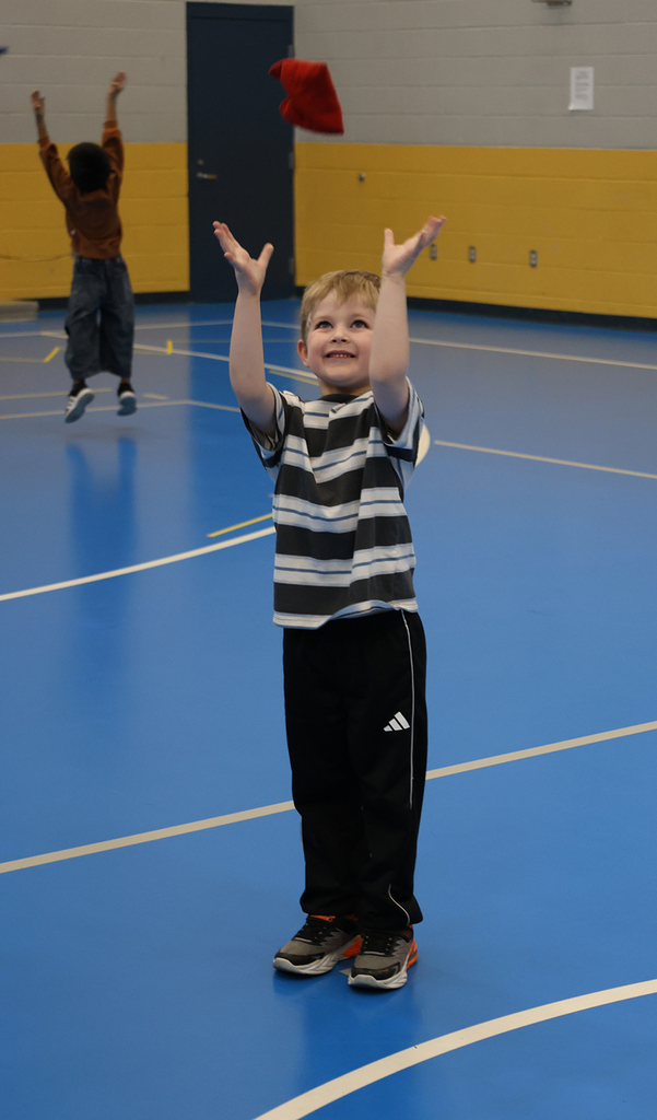 A young boy is ready to catch a bag coming down