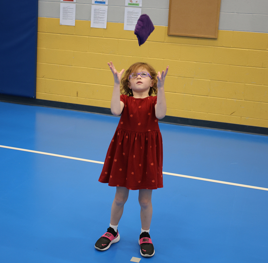 A young girl gets ready to catch her bag in the air