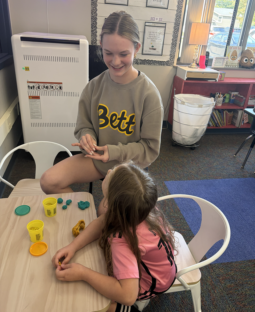 HS student molding playdough with a NA student