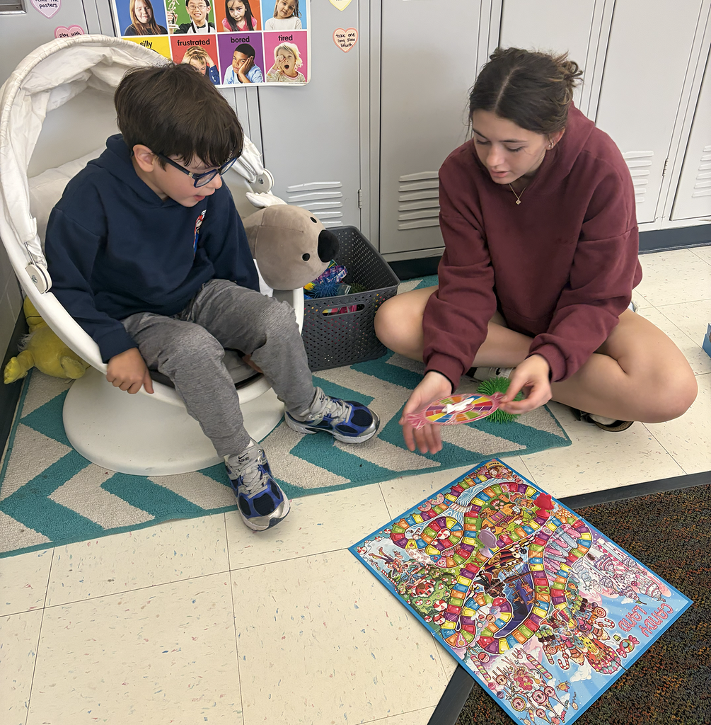 A HS student playing Candy Land with a NA student