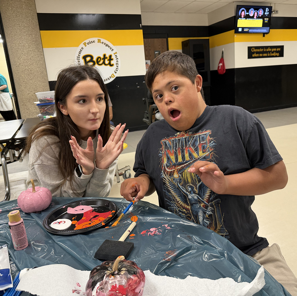 Two students working on pumkins - one with a great surprised face.