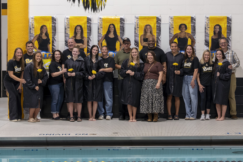 Parents and senior swimmers post for a group picture