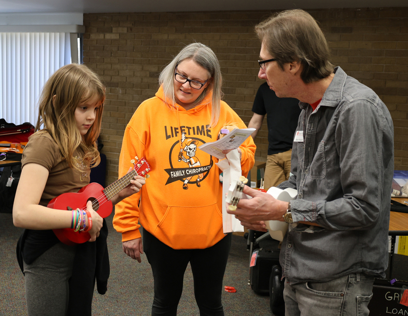 Student learning how to play a ukulele