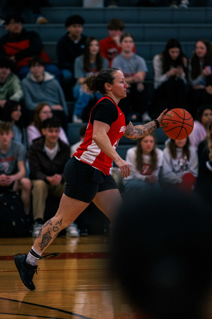 High School students participate in a student-staff basketball game, enjoying school spirit.