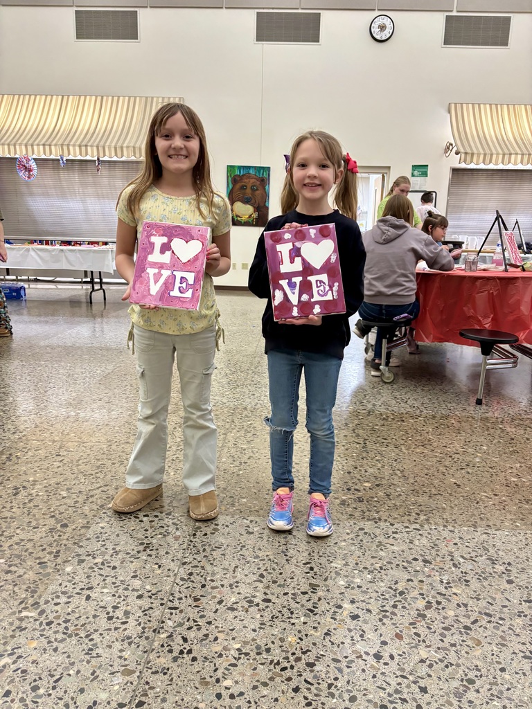 Elementary students pose with their artwork