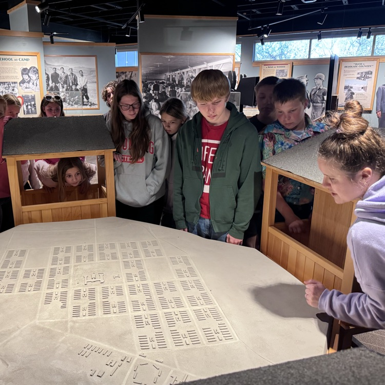 The tour guide showing them what each building was.  
