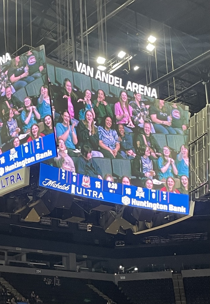 Bella Voce enjoying the game from their seats and seen on a big screen