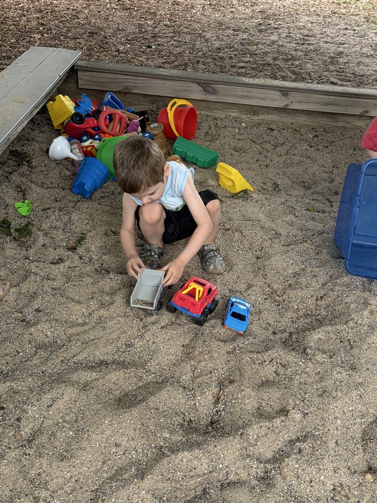 student playing in sand box