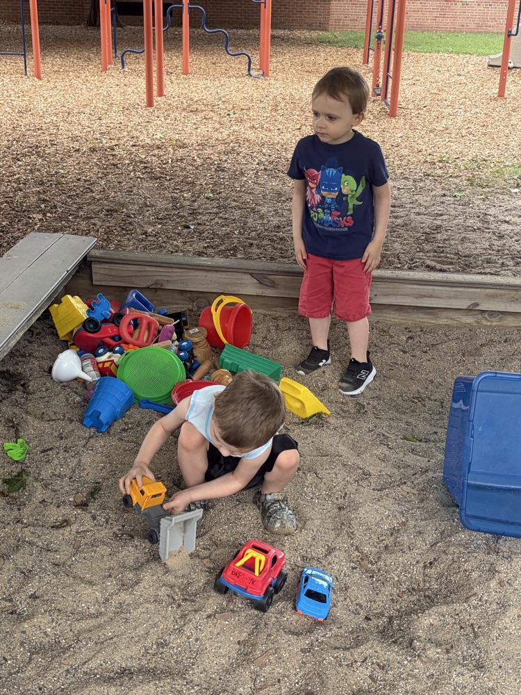 student playing in the sand box