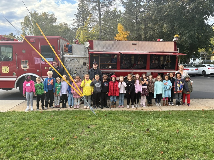 A class posing in front of the firetruck