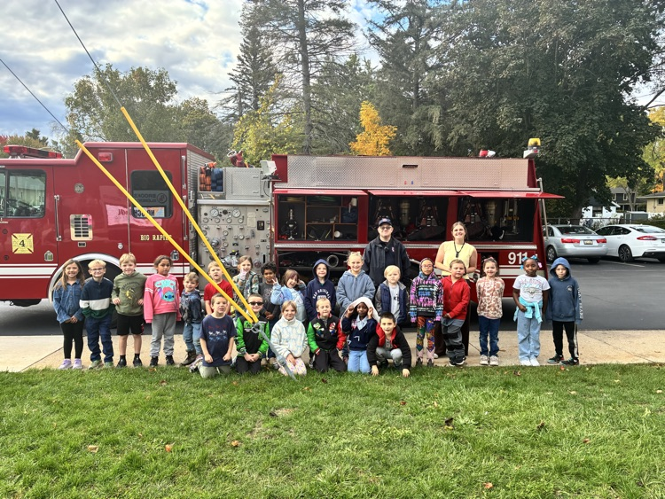 A class posing in front of the firetruck