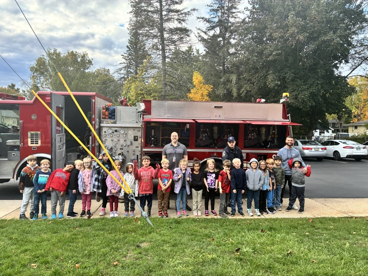 A class posing in front of the firetruck