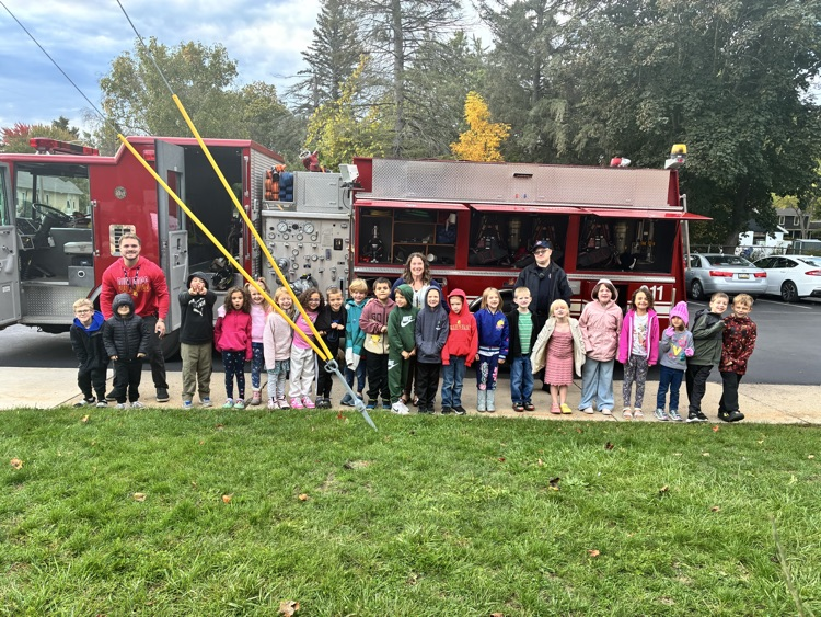 A class posing in front of the firetruck