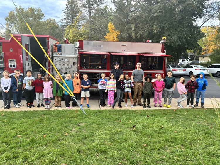 A class posing in front of the firetruck