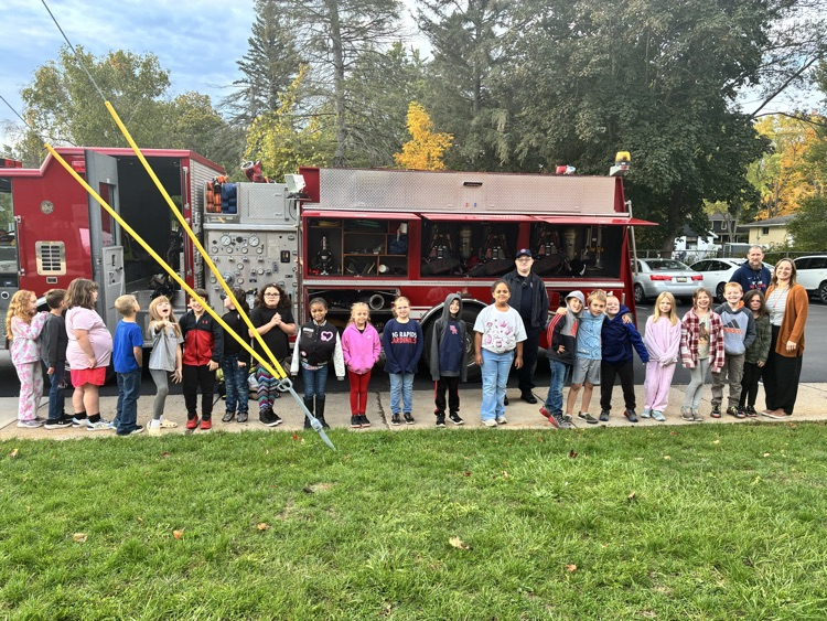 A class posing in front of the firetruck