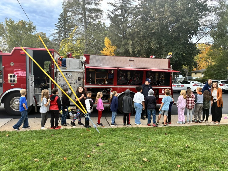 A class posing in front of the firetruck