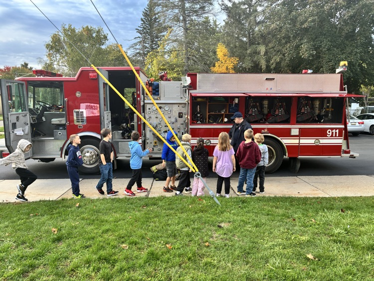 A class posing in front of the firetruck