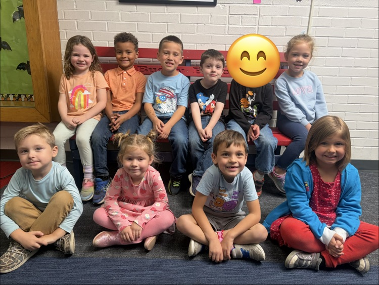 students sitting on a bench in hallway 
