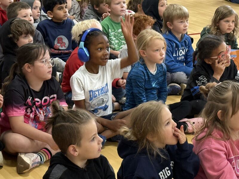Student raising his hand in a crowd of students